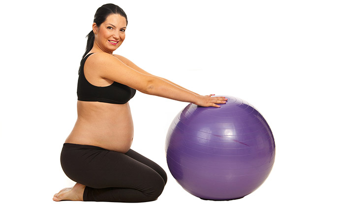 Mujer embarazada con un balón de pilates en Salud para Todos Parla